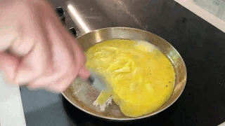 Scrambled eggs being stirred in a small skillet on the stovetop for the Barbaro Mojo breakfast bagel