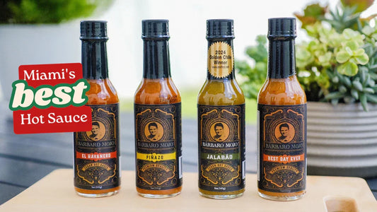 Four Barbaro Mojo bottles, El Havanero, Piñazo, Jalabáo and Best Day Ever, lined up on a patio table under a Miami's Best Hot Sauce badge