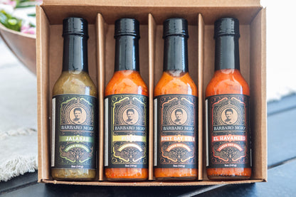 Open kraft gift box with four Barbaro Mojo hot sauces: Jalabáo, Piñazo, Best Day Ever and El Havanero