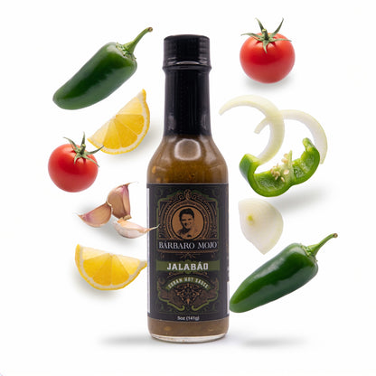 Barbaro Mojo Jalabáo bottle surrounded by jalapeños, green bell pepper, tomato, lemon, onion and garlic